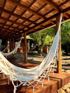 a hammock on a deck with a pergola at Pousadinha in Ilha do Mel +133 photos