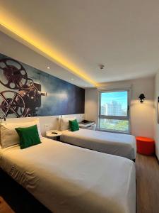 a hotel room with two beds and a large window at ibis Styles Montevideo Biarritz in Montevideo