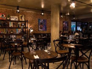 a restaurant with tables and chairs and a brick wall at ibis Styles Montevideo Biarritz in Montevideo +96 photos