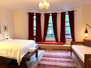 a bedroom with a bed and a couch and two windows at Luxurious bedroom in New York