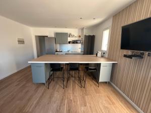 Saint-HippolyteにあるL'instant fleuriの部屋にスツール付きの大きなアイランドキッチン +2枚の写真