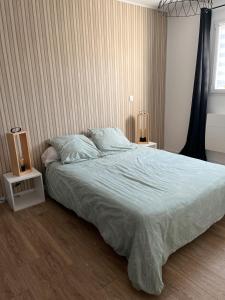 a bedroom with a large bed and two night stands at L'instant fleuri in Saint-Hippolyte