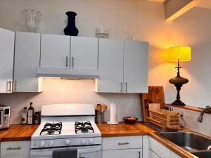 a kitchen with white cabinets and a stove and a sink at Luxurious bedroom in New York +8 photos