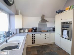 a kitchen with white cabinets and a sink at Lenny's Place in Saint Decumans