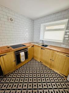 a kitchen with wooden cabinets and a sink and a window at Market Valley in Abertillery +2 photos