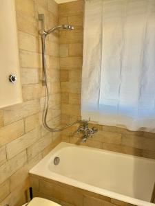a bathroom with a white tub and a toilet at Stura Home in Rome +23 photos