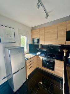 a kitchen with wooden cabinets and a stainless steel refrigerator at Exclusives Apartment in Essen Rüttenscheid in Essen