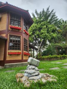 a rock sitting in the grass in front of a house at Pousada Viking Penedo in Penedo