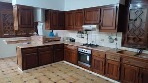 a kitchen with wooden cabinets and a stove top oven at Azur villa in Sfax