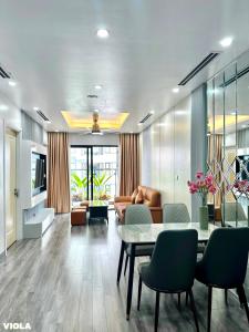 un salon avec une table et un canapé dans l'établissement Viola Imperia Apart Charming Luxury 2Brs SwimPool, à Hanoï