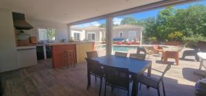 Una sala de estar con una mesa y una cocina y un patio. en Villa Monplaisir, en Montolieu