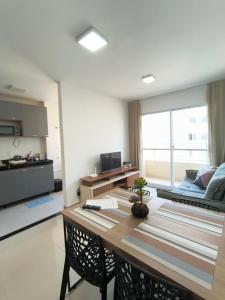 a living room with a table and a couch at Espaço Aruba l Apê confortável perto da Praia in São Luís