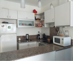a kitchen with a white refrigerator and a microwave at Comfortable Apartamento Semi Piso in Buenos Aires