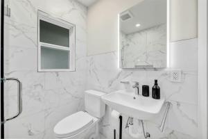 ein weißes Badezimmer mit Toilette und Waschbecken in der Unterkunft Cozy studio in quiet area - Yard in Austin