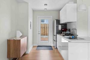 a kitchen with white cabinets and a door to a room at Superb location steps to DT and UT in Austin