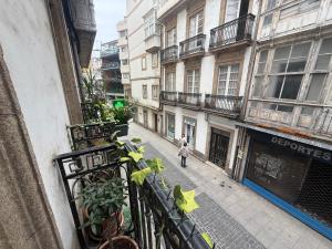 a person walking down a city street with buildings at Estrecha de San Andres in A Coruña