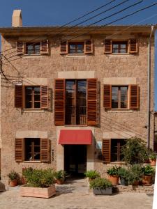 un edificio con ventanas y un toldo rojo en Marton Valldemossa Turismo de Interior, en Valldemossa