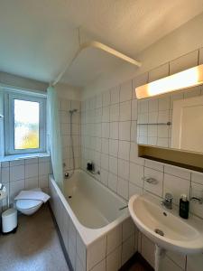 een badkamer met een bad, een wastafel en een toilet bij Comfort escape on Schwandenwiesen in Zürich