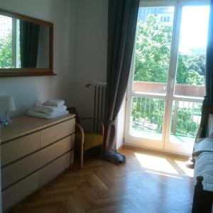 a bedroom with a dresser and a large window at Center Apartment in Warsaw