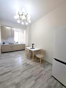 a kitchen with a table and chairs and a refrigerator at Стильная студия в центре с кухней in Bukhara