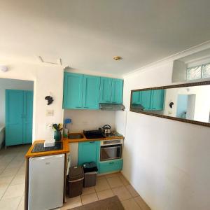 a kitchen with blue cabinets and a sink and a stove at Seaside haven in Simonʼs Town +12 photos