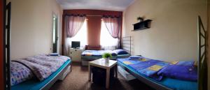1 Schlafzimmer mit 2 Betten, einem Tisch und einem Fenster in der Unterkunft Ferrara B&B Motel in Wągrowiec