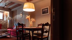 a dining room with a table and chairs and a couch at Hotel El Cerco in Puente la Reina