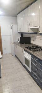 a kitchen with a stove and a refrigerator at Habitación en piso compartido in Terrassa