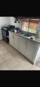 een keuken met een spoelbak en een fornuis bij santo domingo airport villa in Reparto Esther Rosario