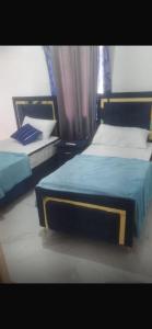 twee eenpersoonsbedden in een slaapkamer met een raam bij santo domingo airport villa in Reparto Esther Rosario