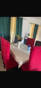 een tafel met rode stoelen en een tafel met een wit tafelkleed bij santo domingo airport villa in Reparto Esther Rosario +2 foto's