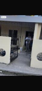 een gebouw met een poort en een persoon die buiten staat bij santo domingo airport villa in Reparto Esther Rosario
