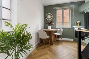 a kitchen and dining room with a table and a plant at Pippin - Stylish City Centre Studio - Worcester in Worcester