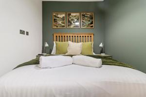 a bedroom with a large white bed with two lamps at Pippin - Stylish City Centre Studio - Worcester in Worcester