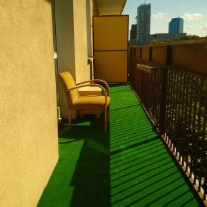 a balcony with green flooring on a building at Center Apartment in Warsaw