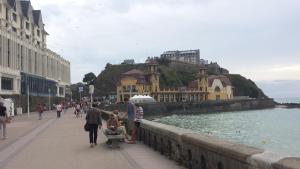 un grupo de personas caminando por una acera cerca del agua en Cryste Marine, en Granville 9 fotos más