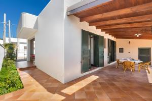 a patio with a table and chairs on a house at Villa Simona - Torre Lapillo in Isola della Malva