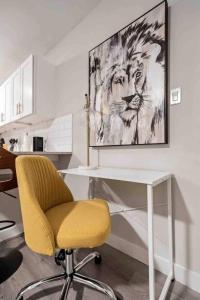 a desk with a yellow chair and a painting of a lion at Steps away from Downtown Restaurants and Bars - King Bed in Austin