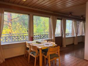 une salle à manger avec une table, des chaises et des fenêtres dans l'établissement Casa Peipponen, à Kuopio