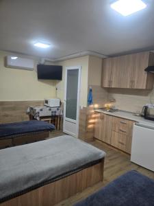 Habitación con 2 camas y cocina con fregadero. en Petite Chambre, en Velyatyn