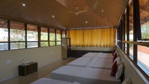 a room with four beds in a room with windows at Chirooss Homestays And Resorts in Chikmagalūr +59 photos