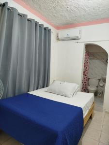 a bedroom with a blue bed and a toilet at Hotel El Almendro in Pedernales +9 photos
