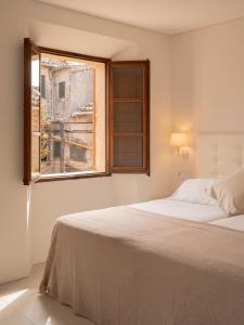 Un dormitorio blanco con una cama y una ventana. en Marton Valldemossa Turismo de Interior, en Valldemossa