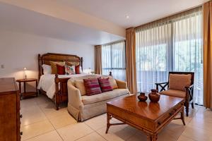 a living room with a bed and a couch and a table at Majestic Colonial Villa Private Pool Jacuzzi and Gardens in Ocotepec +92 photos