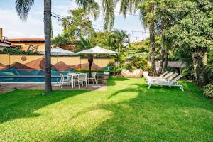 a yard with a table and chairs and palm trees at Majestic Colonial Villa Private Pool Jacuzzi and Gardens in Ocotepec