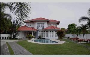 a large house with a swimming pool in front of it at Cs white house negombo in Negombo