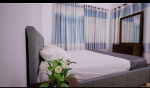 a bedroom with a bed and a vase of flowers at Cs white house negombo in Negombo