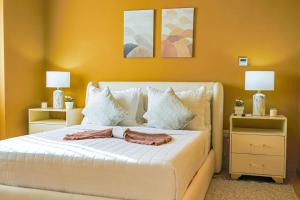 a bedroom with a white bed with two night stands at Elegant and Cozy 1BD Condo in Ensanche Quisqueya +29 photos