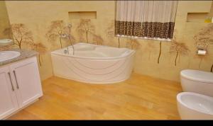 a bathroom with a bath tub and a toilet at Cs white house negombo in Negombo +22 photos