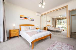 a bedroom with a large bed and a mirror at Peaceful Bushland Retreat with Treetop Hills Views in Wonga Park +32 photos